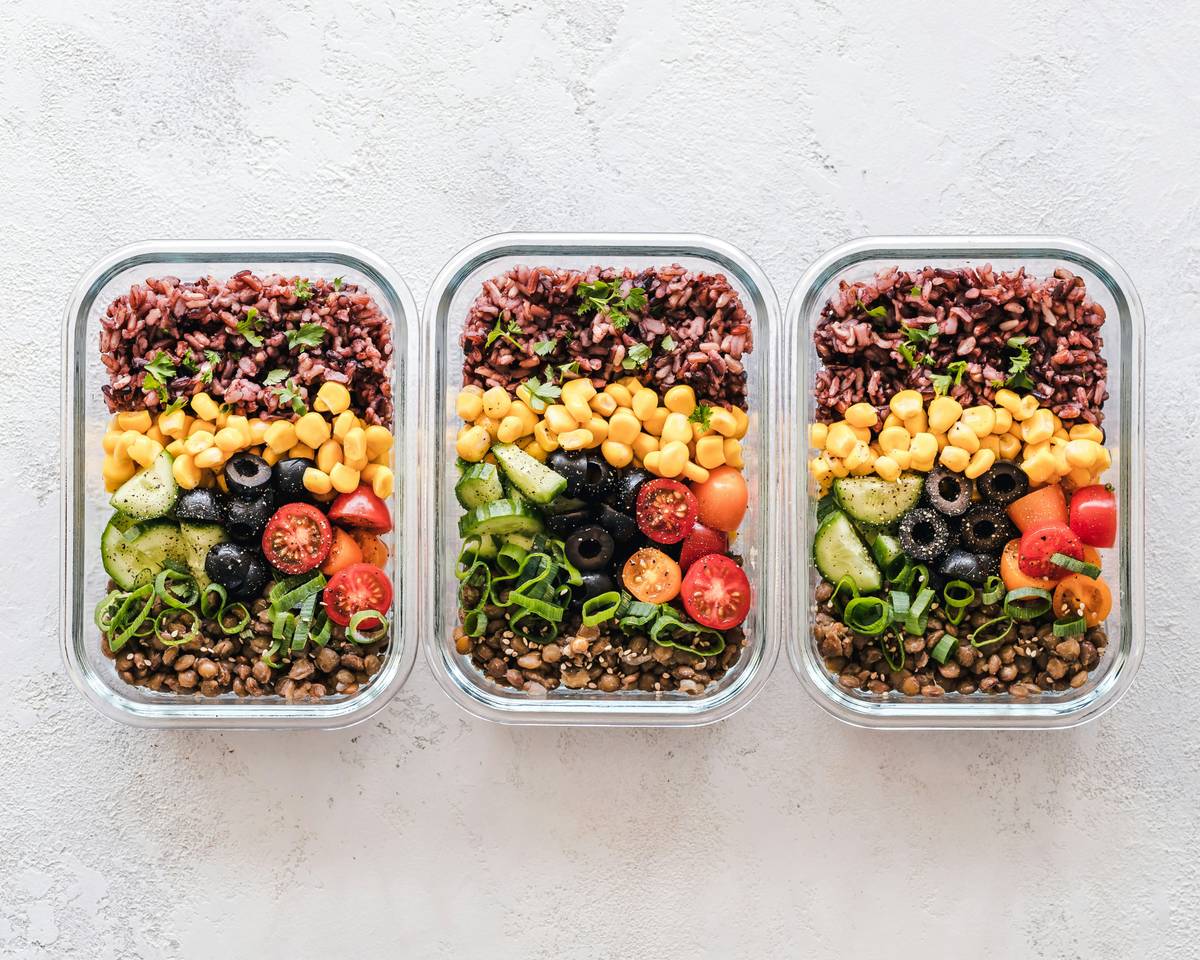eating well meal plan featuring colorful bowls of lentils, roasted veggies, brown rice, and avocado