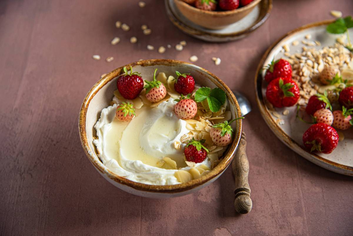Colorful bowl of gut-friendly foods like yogurt, berries, oats, and sauerkraut labeled eating for healthy gut
